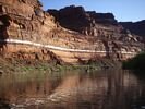 A raft floating on glassy water reflecting a rose colored cliff in the background