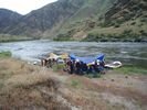 A rafting trip campsite with two para-wing shelters pitched to cover the camping area