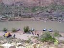 View down onto a pink colored camp site with rafts pulled up on the shore
