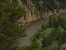 View from high above of a lone red raft floating through a gorgeous green landscape