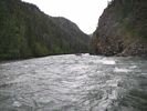 A group of white water rafts disappearing in the distance on swift bouncy river