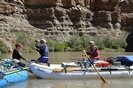 People on whitewater rafts passing bottle of Jaegermeister on rafting trip through the Grand Canyon