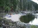 The view from a distance of Black Canyon Beach Camp beside glassy green water