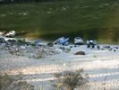 Looking down at four rafts and some women sitting on the beach at Johnson Creek Camp on the Main Salmon River