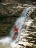 A girl in a red shirt standing under a water fall