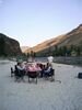 A group on a rafting trip, sitting at a table with a checked table cloth