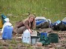 A girl settling and filtering water on a gravel bar beside the Green River