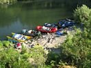 Looking down at brightly colored rafts on shore in morning light