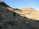 Three women descending a hillside.