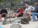 Four men talking around a campfire