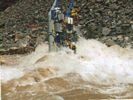 A large cataraft getting flipped lenght-wise in a big rapid