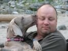 A dog giving a man a big wet kiss on the cheek