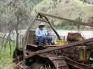 A man sitting on an abandoned bulldozer beside the South Fork of the Salmon River