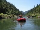 Man rowing an 18ft self bailing raft showing his muscles on the Rogue River, Oregon